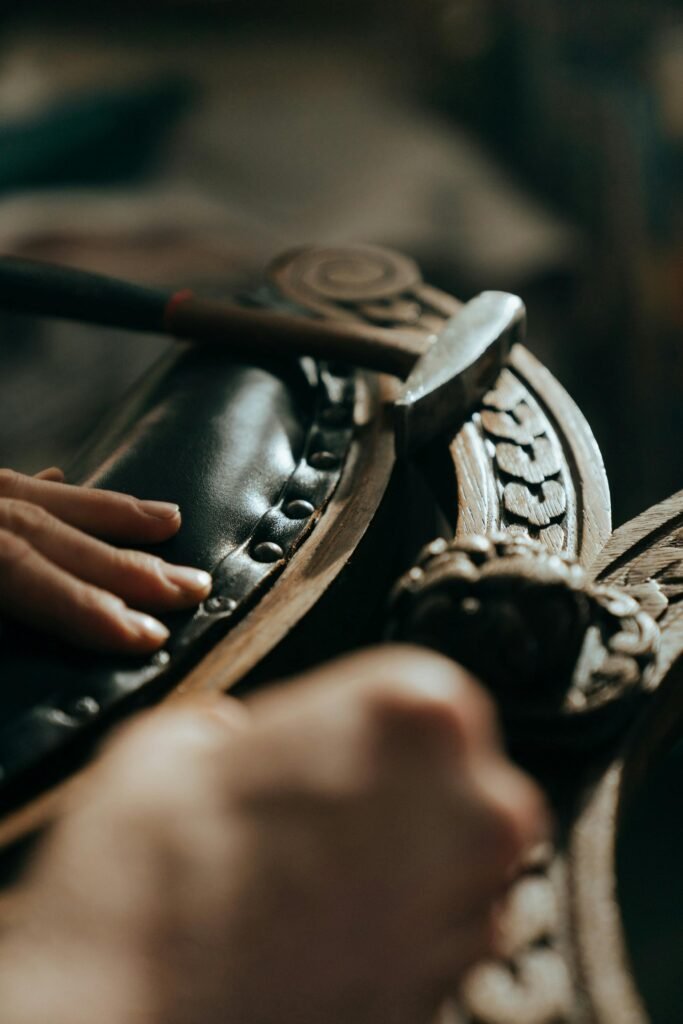 pexels-photo-5095274-5095274 Close-up of skilled hands restoring antique wooden furniture with intricate carvings.